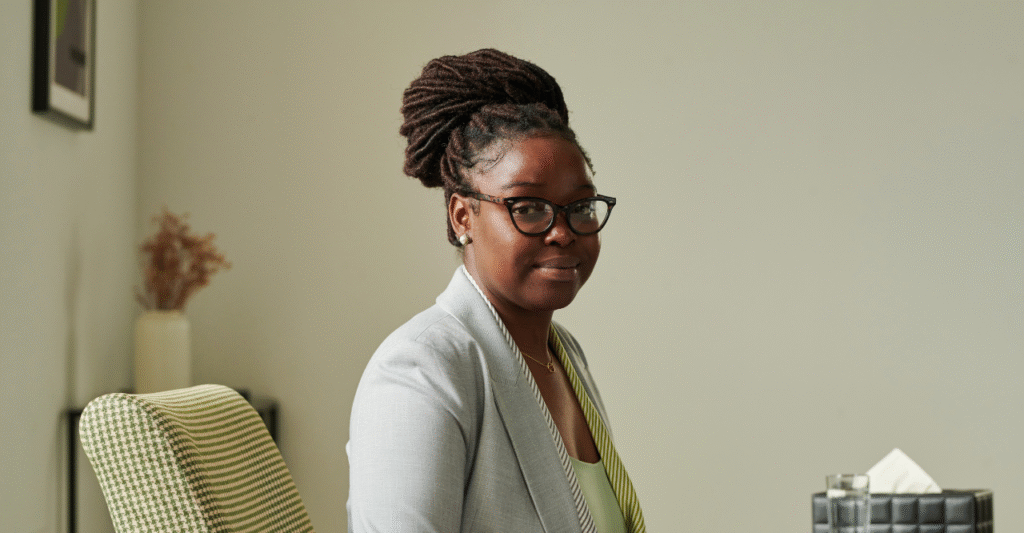 Vrouw die de camera inkijkt in een rustige omgeving.